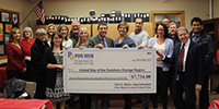 Sixteen Pine Bush district employees present an oversized check to the United Way.