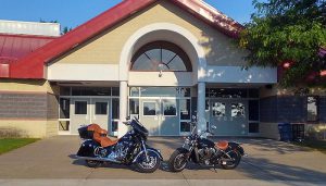 Two motorcycles are parked in front of Pine Bush High School