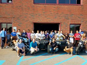 A group of students surround a motorcycle that was donated