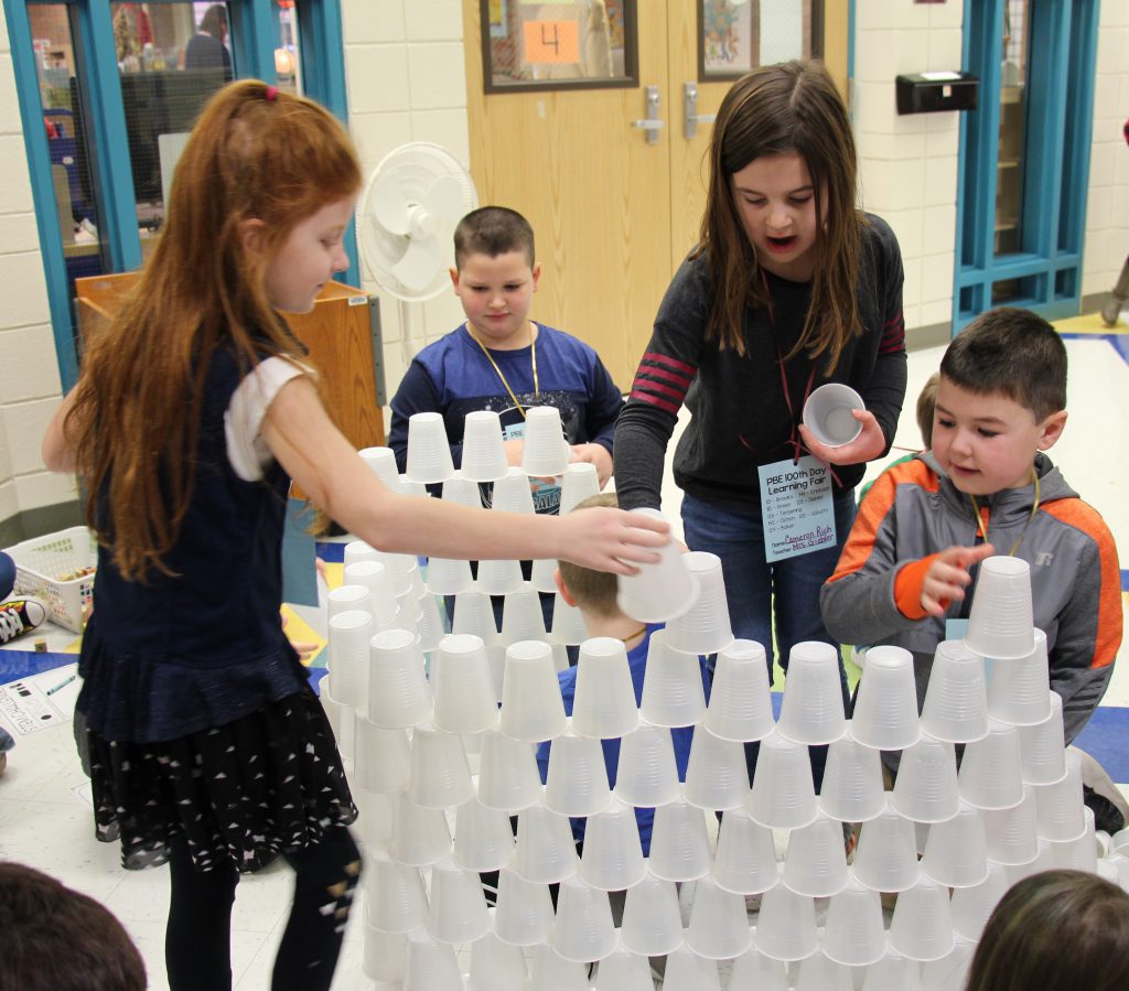 Four elementary students build a 100-cup wall 