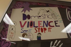 A sign that says Domestic Violence Stop it, with drawings of people around it.