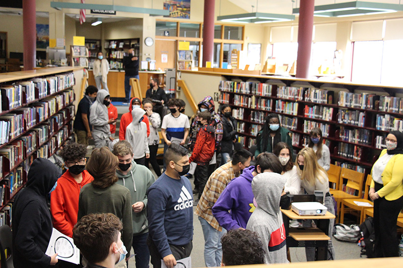 High school students in a library mulling about.