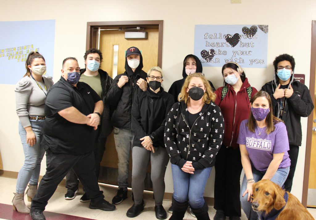 A group of six students and five teachers standing together. All are wearing masks.