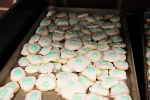 A tray of cookies. They are white with a green dot in the center, like green eggs.