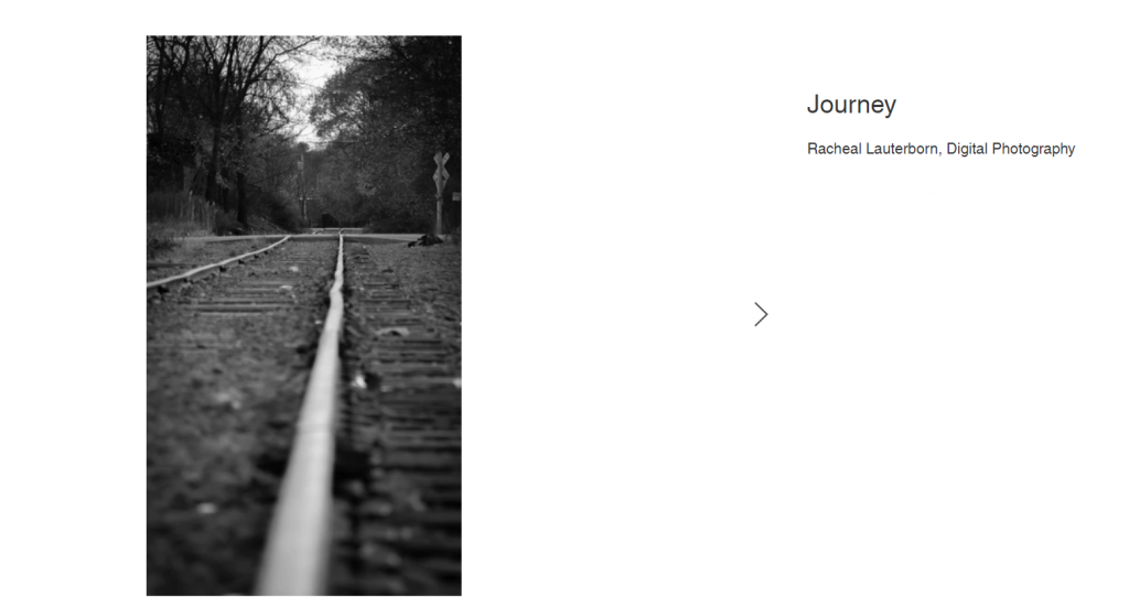 A black and white photo at ground level looking down railroad tracks. 