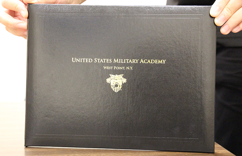 a black folder with gold imprint. It says United States Military Academy West Point , N.Y.