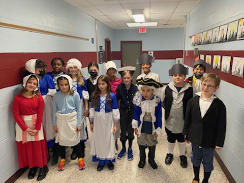 A large group of fourth-grade students all dressed in colonial costumes.