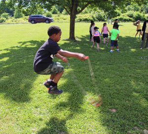 An elementary boy jumps rope.