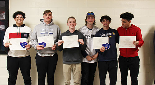 A group of six young men, high school age, stand together. All are holding certificates. They are smiling.