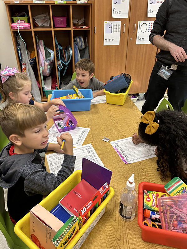 A group of first-grade students work on papers  together.