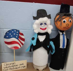 Two soda bottles decorated to look like George Washington and Abraham Lincoln