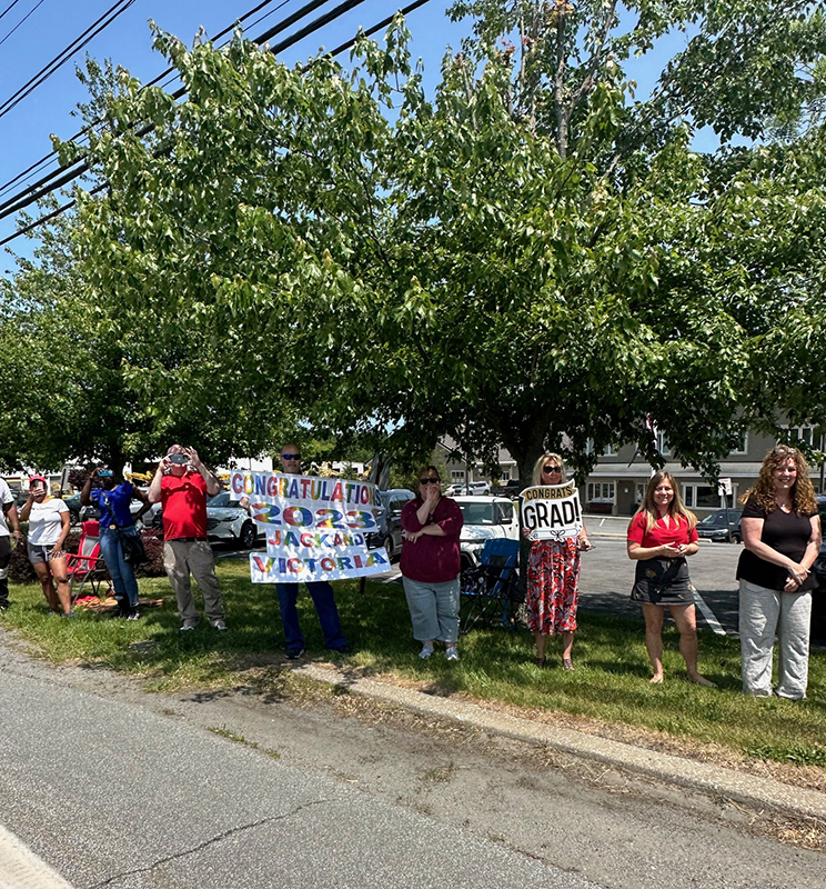 A large group of residents hold signs supporting the seniors.