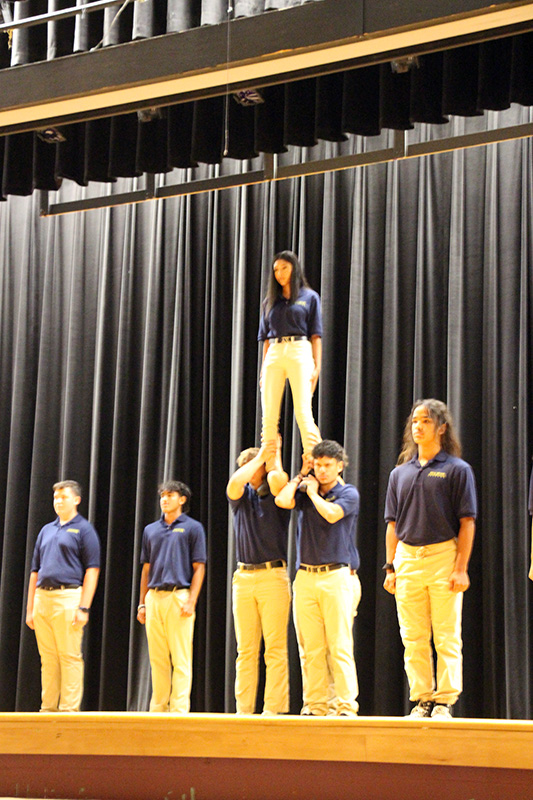 A group of six high school students in a pyramid formation.