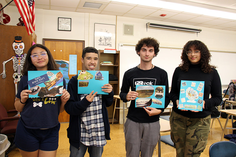 Four high school students hold up their vision boards. They are smiling.