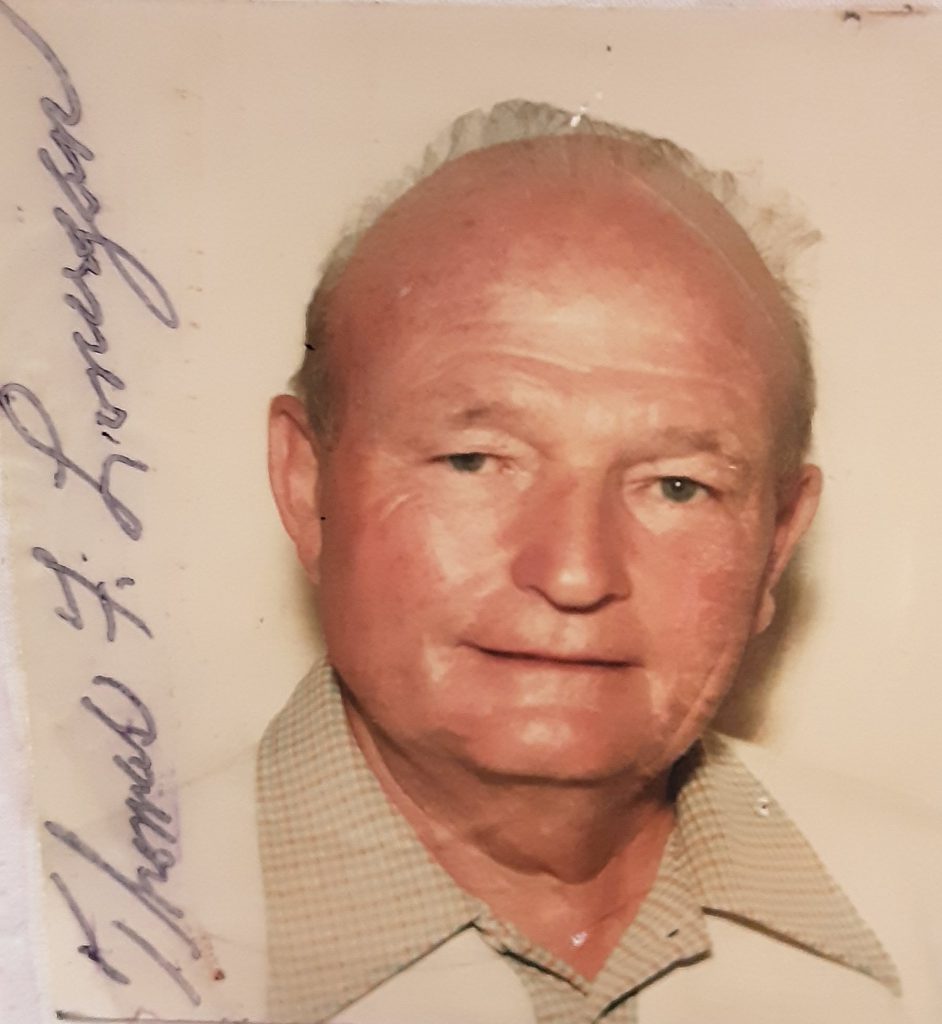 An older man smiles in a very old photo.