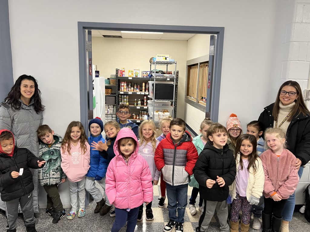 A class of kindergarten students pose with their teachers.