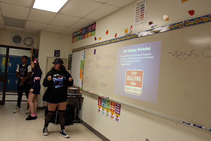 High school students stand in front of a class giving a bullying seminar.