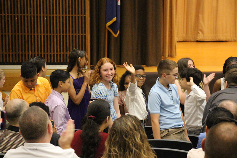 Fifth-grade students wave to their families during their moving-up ceremony.