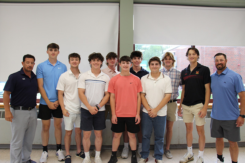 Men on either side. There are nine high school boys standing between them in two rows. They are all smiling.