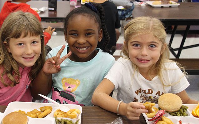 Three elementary girls smiling