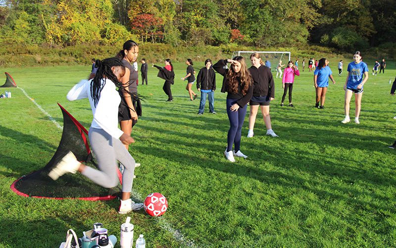 Middle school students play soccer on a beautiful sunny day.