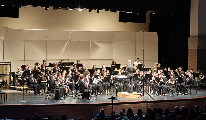 Student musicians perform on a stage.