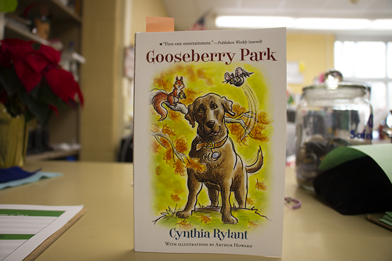 A book stands up on a counter. It says Gooseberry Park and has a picture of a dog on it.