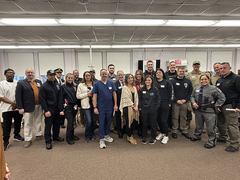 A group of 22 adults stand together for a group picture.