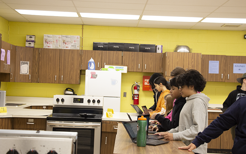 Young woman veteran talks to middle school students about her service