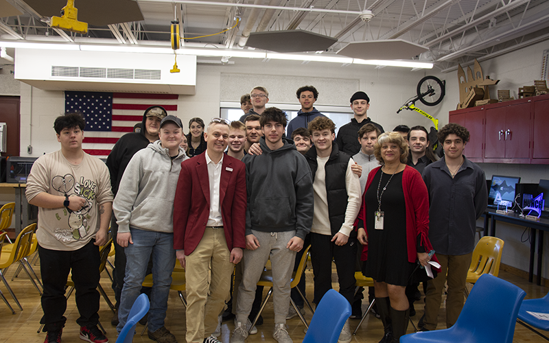 A group of high school kids all stand together with two adults.