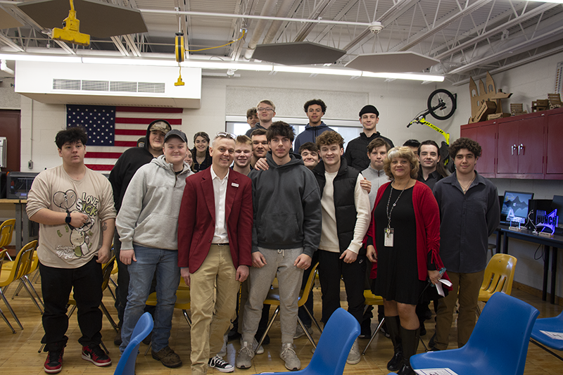 A group of high school kids all stand together with two adults.